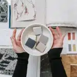 Personne aménageant une pièce avec des échantillons de couleurs et des objets de décoration