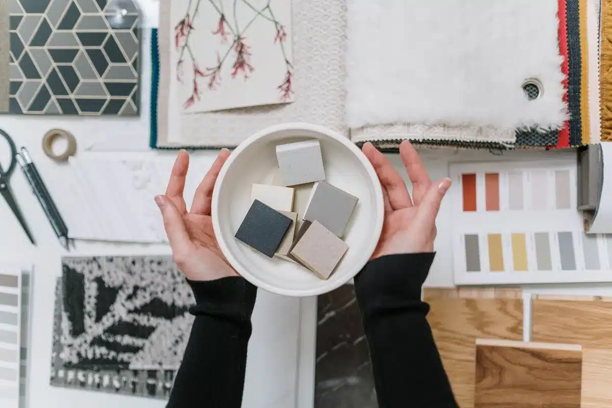 Personne aménageant une pièce avec des échantillons de couleurs et des objets de décoration