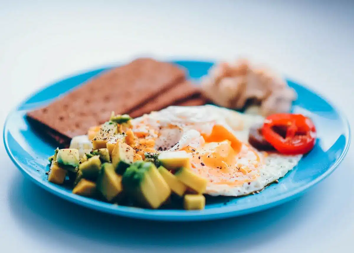 Petit-déjeuner équilibré avec œufs, avocat et céréales complètes