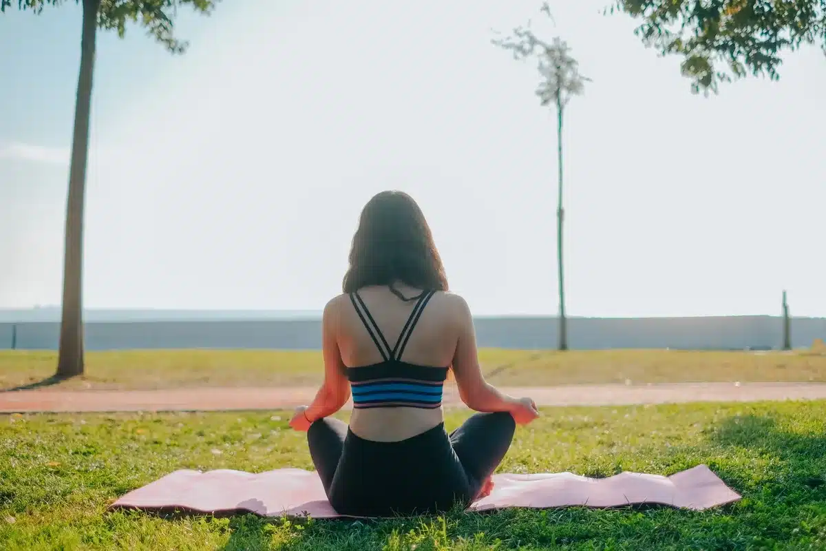 Personne pratiquant le yoga ou la méditation le matin dans un environnement calme