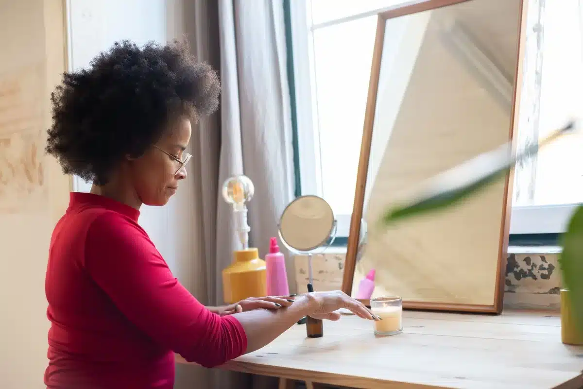 Mains anonymes ajustant un miroir sur une commode vintage en bois