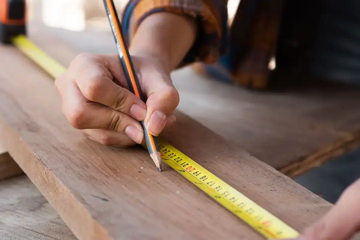 Mesure précise des corbeaux en brique avant la pose du bois