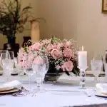 Centre de table élégant avec vase, tiges botaniques et bougie sur un plateau neutre