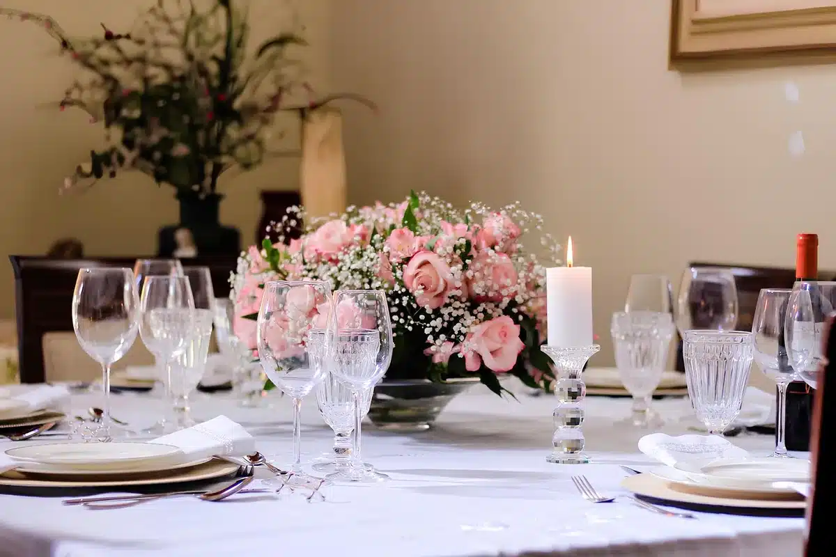 Centre de table élégant avec vase, tiges botaniques et bougie sur un plateau neutre