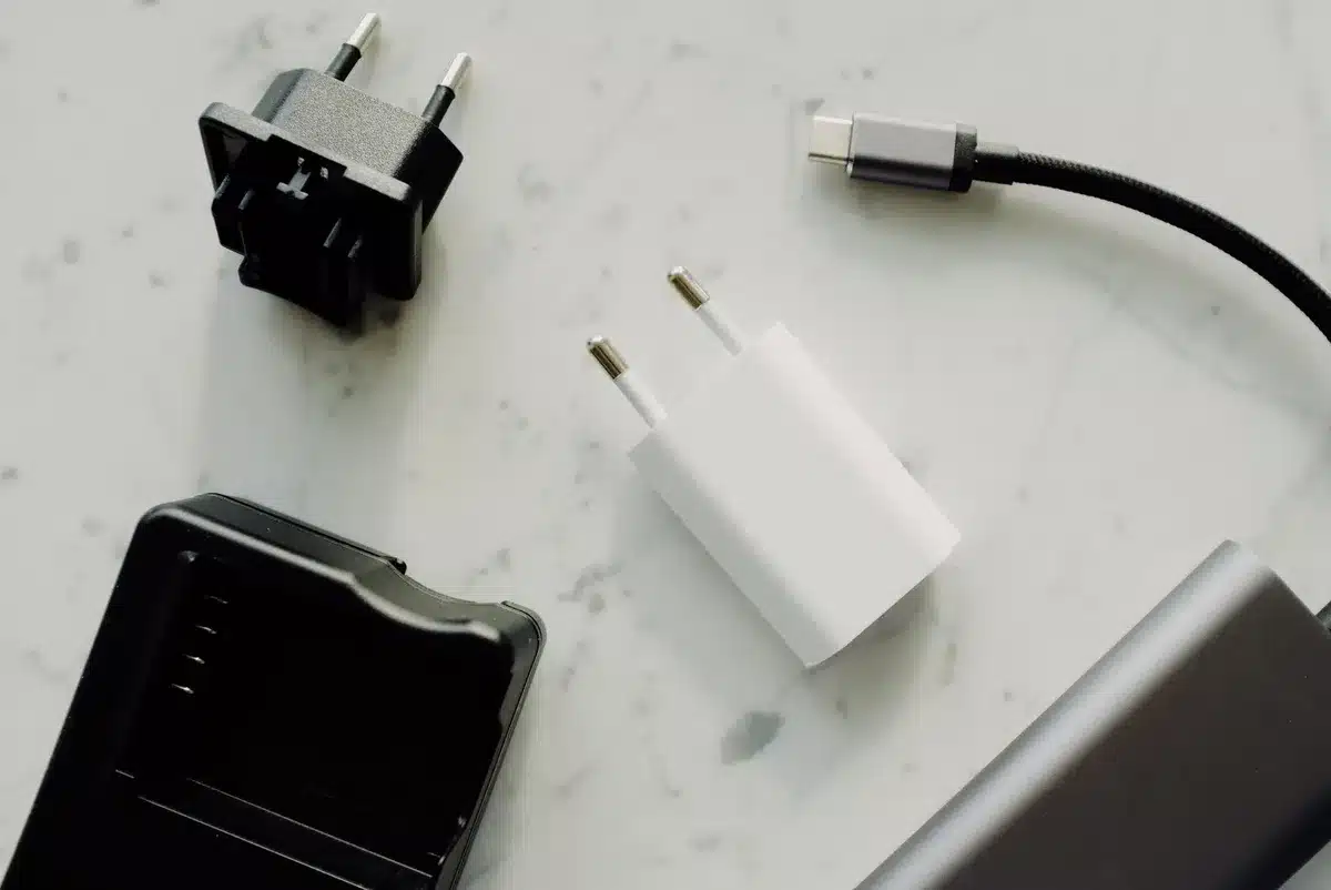 Mains d'une personne débranchant un chargeur de téléphone d'une prise murale