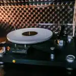 Main vinyl record being placé sur une platine tournante dans une lumière douce