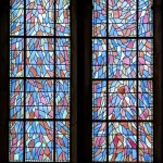 Vitrail rond rétroéclairé diffusant une lumière colorée à travers ses motifs géométriques