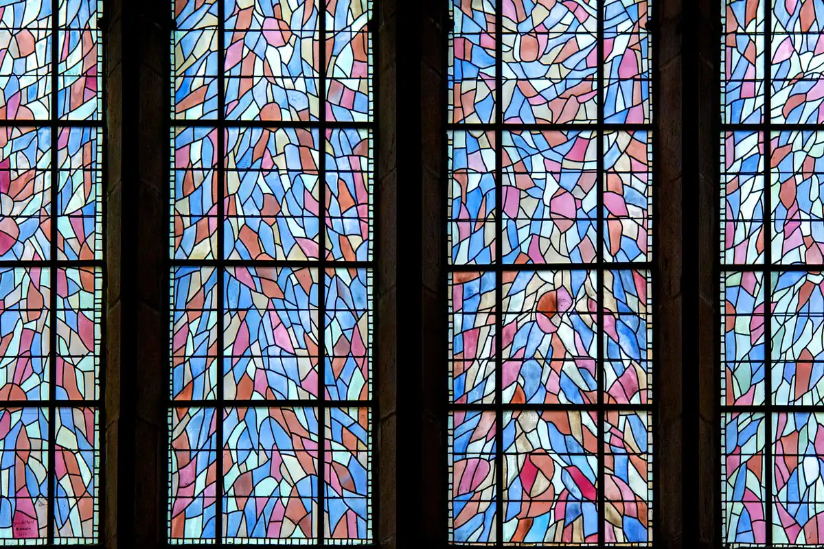 Vitrail rond rétroéclairé diffusant une lumière colorée à travers ses motifs géométriques