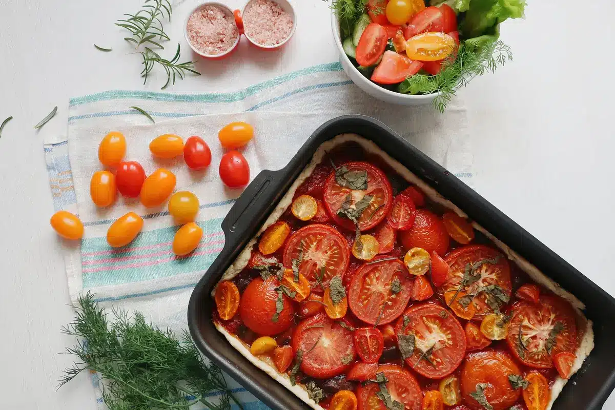 Ingrédients frais : tomates mûres, feuilles de laurier, herbes aromatiques et huile d'olive