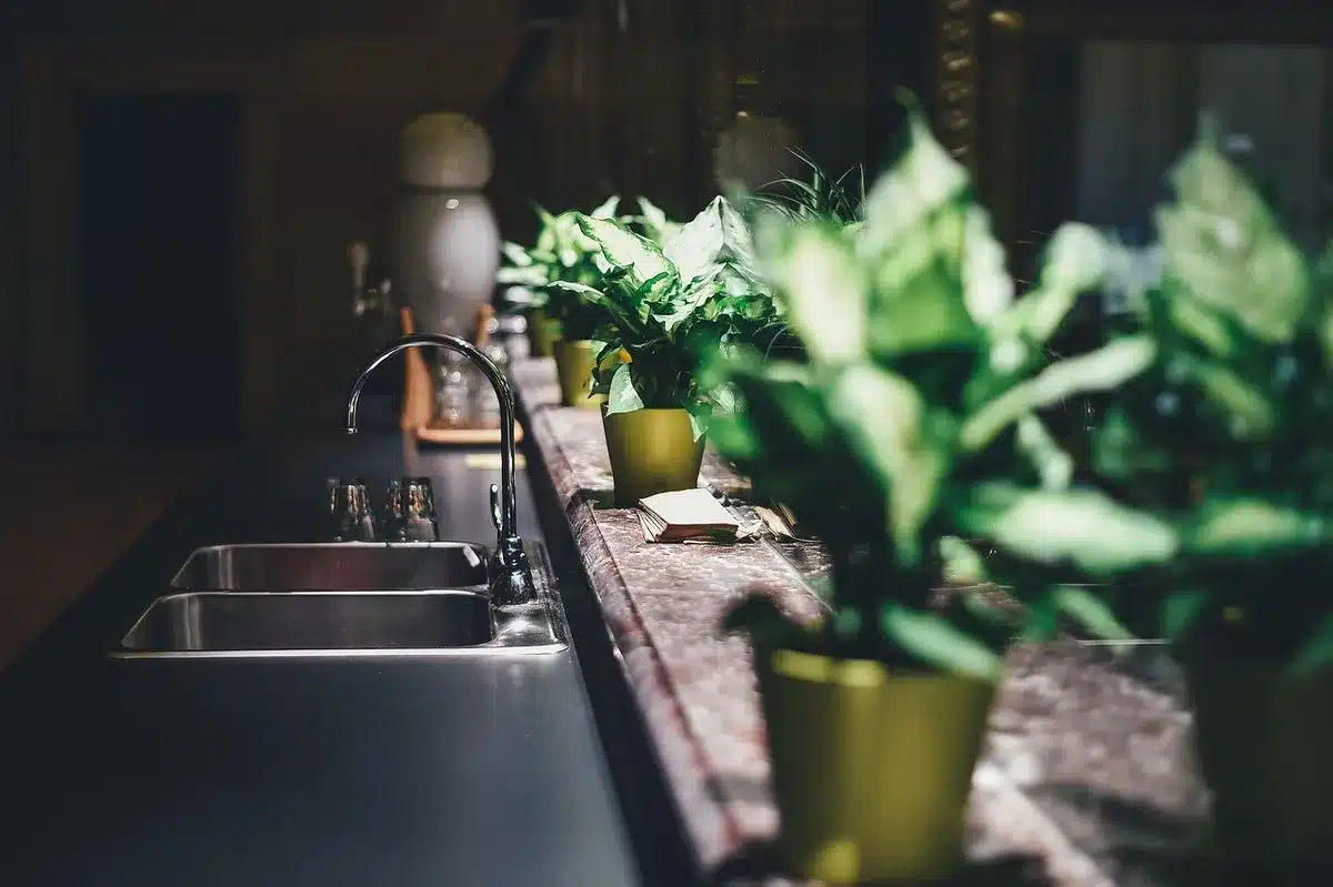 Mains changeant un joint de siphon sous l'évier avec des outils
