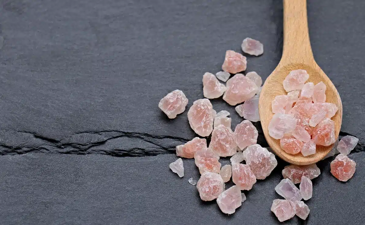 Pot d'huile de coco et cuillère près d'ingrédients de cuisine