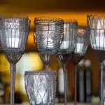 Porte-bougies DIY faits de flûtes en plastique et boules de Noël sur une table, lumière du jour