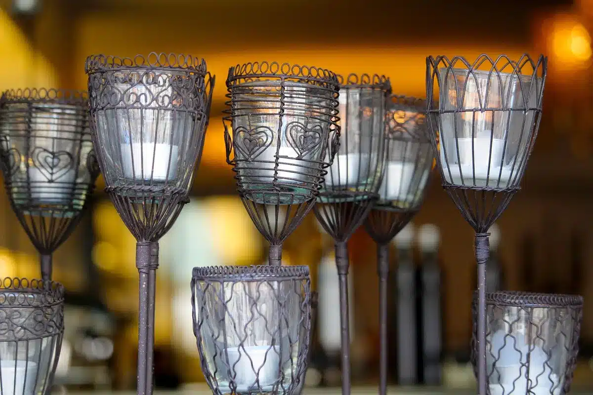Porte-bougies DIY faits de flûtes en plastique et boules de Noël sur une table, lumière du jour