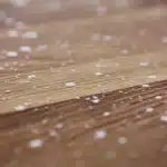 Atelier en plein jour: mains anonymes réparant un panneau de particules sur une table avec outils