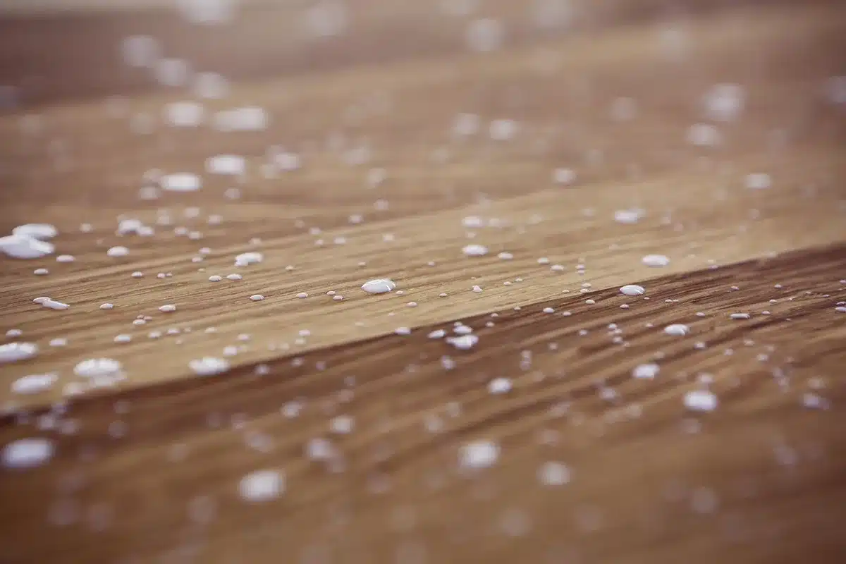 Atelier en plein jour: mains anonymes réparant un panneau de particules sur une table avec outils